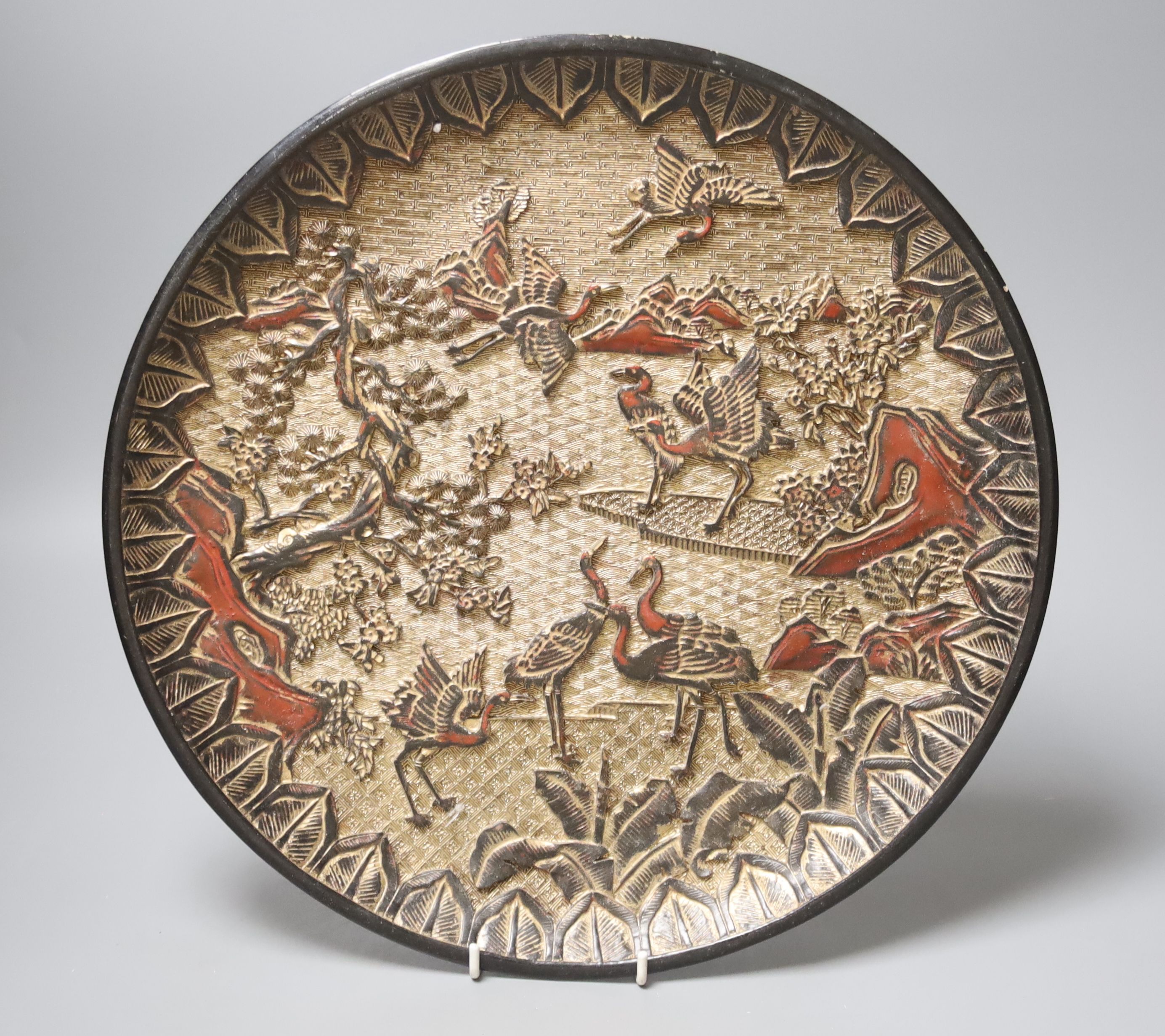 A Chinese laquer dish, carved with storks in a landscape, six character Zhengde marks, 34.5cm diameter